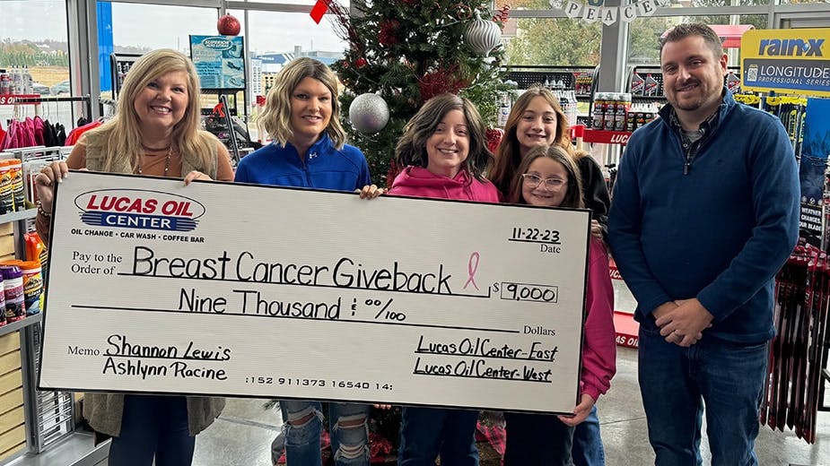 VP of Operations, April Maxey, and marketing manager, Chris Payne, presenting the final total check to recipients Ashlynn Racine (with her two daughters) and Shannon Lewis.